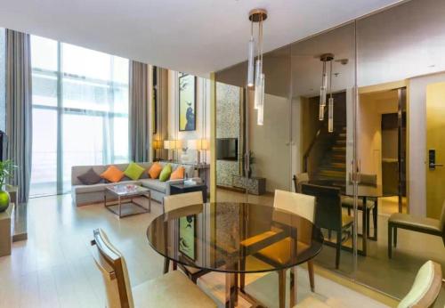 a living room with a glass table and a couch at Huafa Executive Apartment Hotel Zhuhai in Zhuhai