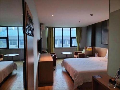 a hotel room with two beds and a television at IU Hotel Changsha Yuanjialing Metro Station 2nd Hospital of Xiangya in Changsha