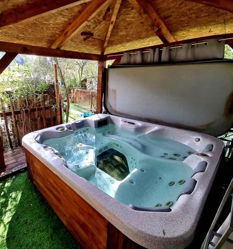 a bath tub in a gazebo at GITES O FIL DE L'EAU piscine spa accès rivière in Omessa