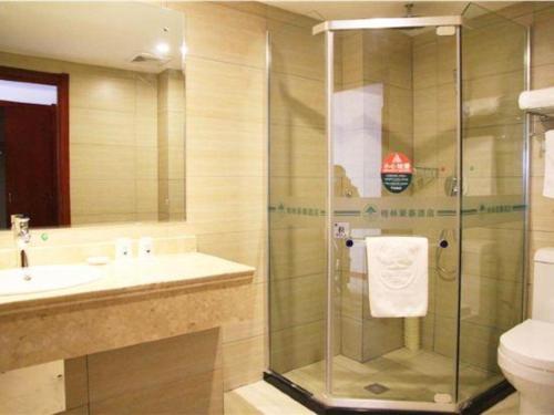 a bathroom with a shower and a sink and a toilet at GreenTree Inn Xian Longshouyuan Subway Station Business Hotel in Xi'an
