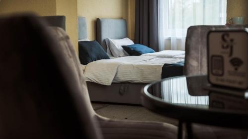 a bedroom with a bed and a table and a chair at SergJuli Villa in Plavecký Štvrtok