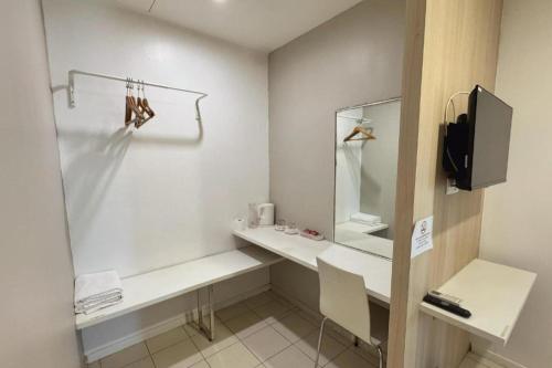 a white bathroom with a desk and a mirror at Country Inn in Johor Bahru