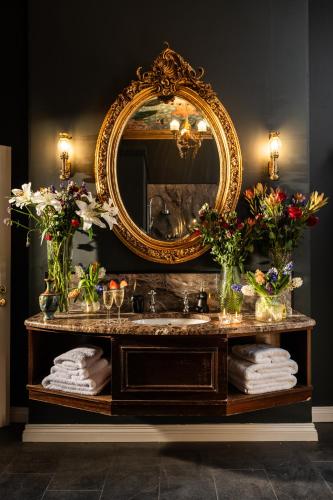 a bathroom with a vanity with a mirror and a sink at The Harrison Chambers of Distinction in Belfast