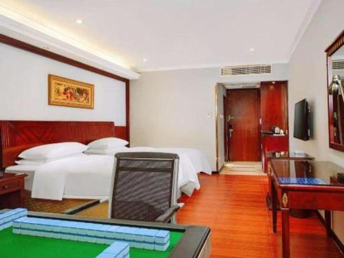 a bedroom with two beds and a pool table at Vienna 3 Best Hotel Dongguan Fenggang Yongsheng Street in Tiantangwei
