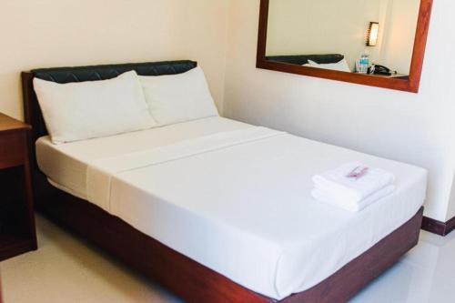 a bed in a room with a mirror at Sabine's Place in Masbate