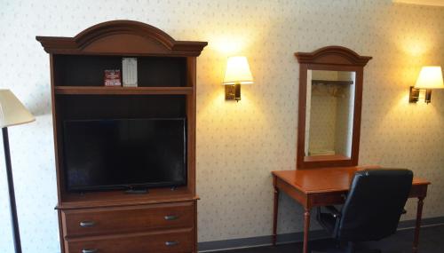 a hotel room with a tv and a desk and a desk at Travelodge by Wyndham Milwaukee in Milwaukee