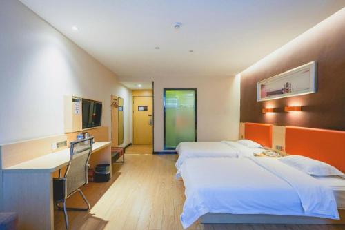 une chambre d'hôtel avec deux lits et un bureau dans l'établissement 7 Days Premium Nanchang Xiaolan Industrial Park Bogang Metro Station, à Lianxi