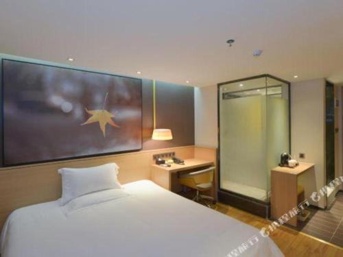 a hotel room with a large bed and a desk at IU Hotel Anshun Zhenning Huangguoshu Scenic Area Toursit Center in Anshun