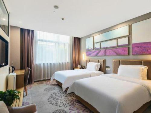 a hotel room with two beds and a tv at Lavande Hotel Xi'an Longshouyuan Wenjing Road in Xi'an