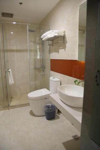 a bathroom with a shower and a toilet and a sink at 7 Days Premium Yancheng Dafeng Zhongjiao Meilu City in Yancheng