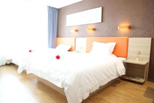a bedroom with two beds with white sheets at 7 Days Premium Yancheng Dafeng Zhongjiao Meilu City in Yancheng
