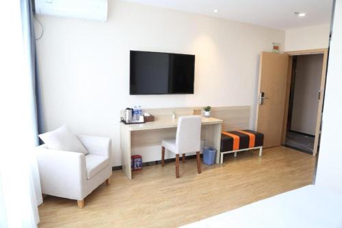 a room with a desk and a chair and a tv at 7 Days Premium Yancheng Dafeng Zhongjiao Meilu City in Yancheng