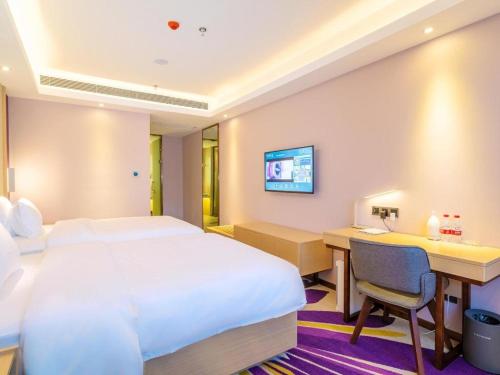 a hotel room with a bed and a desk at Lavande Hotels· Guizhou Anshun Xi Railway Station in Anshun