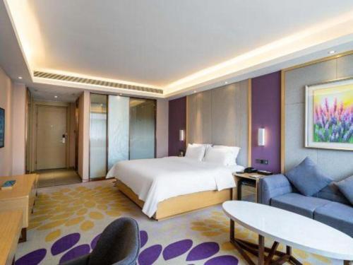 a hotel room with a bed and a couch at Lavande Hotels· Guizhou Anshun Xi Railway Station in Anshun