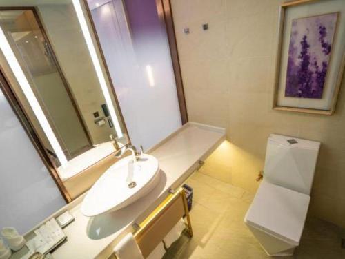 a bathroom with a sink and a mirror and a toilet at Lavande Hotels· Guizhou Anshun Xi Railway Station in Anshun