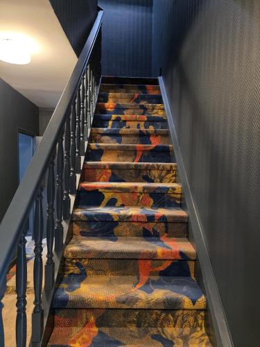 a set of stairs with colorful carpet on them at Logis - Hostellerie Saint-Louis & Restaurant Pauze in Bollezeele