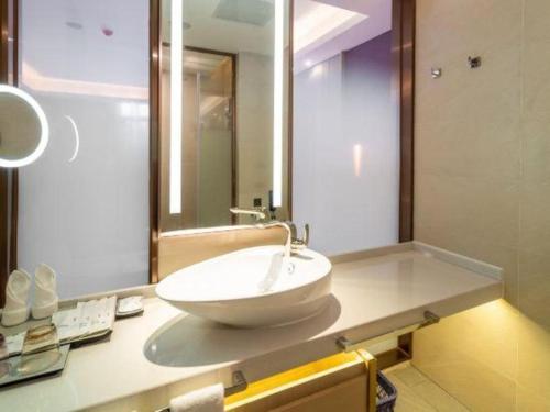 a bathroom with a sink and a large mirror at Lavande Hotels· Guizhou Anshun Xi Railway Station in Anshun