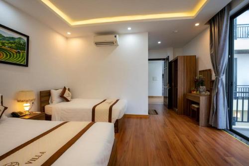a hotel room with two beds and a window at Hoi An Paradise Villa in Hoi An