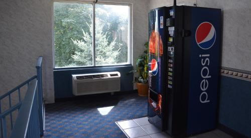 a pepsi cola machine in a room with a window at Travelodge by Wyndham Milwaukee in Milwaukee