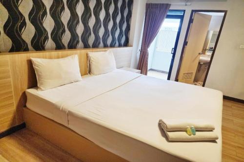 a bedroom with a large white bed with a mirror at Station 203 Hotel in Bangkok