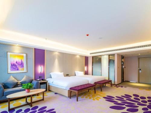 a hotel room with a large bed and a couch at Lavande Hotels· Guizhou Anshun Xi Railway Station in Anshun