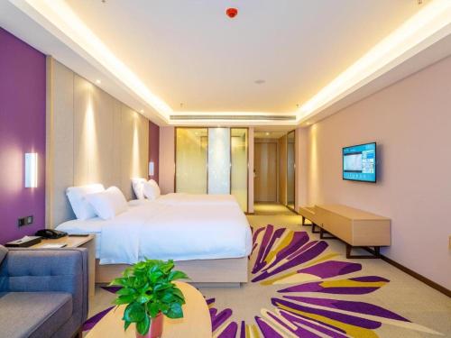 a hotel room with a bed and a couch at Lavande Hotels· Guizhou Anshun Xi Railway Station in Anshun