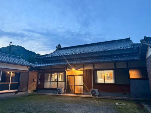 une maison éclairée devant elle dans l'établissement 古民家宿りらいふ, à Kitsuki