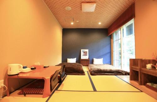 a room with two beds and a desk in it at Fuji Shoei kaikan in Fuji