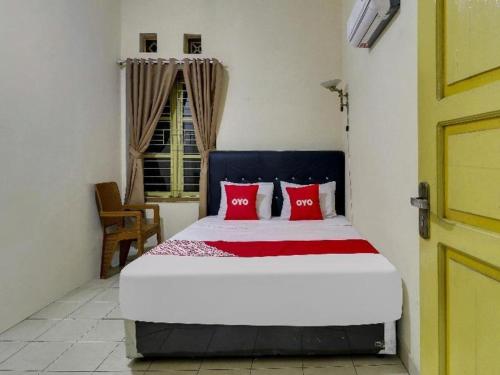 a bedroom with a large bed with red pillows at Hotel O My Guest House Syariah in Bandung