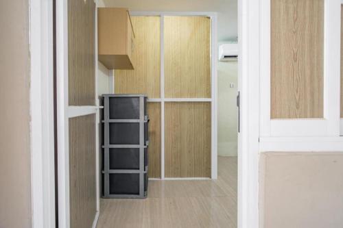 a room with a kitchen with wooden walls and a door at Homely Syariah in Kediri