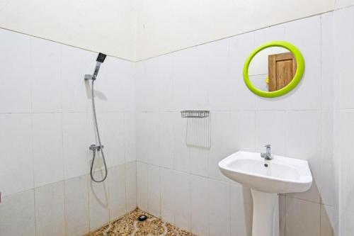 a white bathroom with a sink and a mirror at OYO 93600 Barong Ijo Homestay Syariah in Yogyakarta
