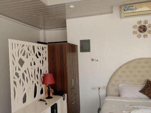 a bedroom with a bed and a table with a lamp at Pilot Hotel in Alaminos