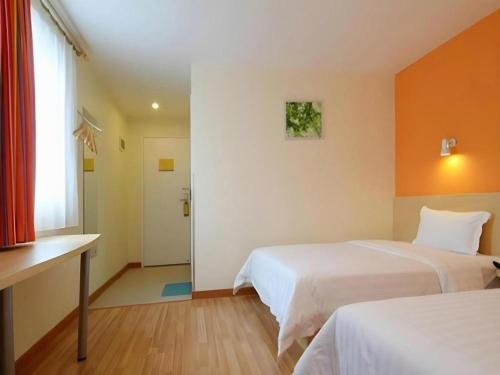 a hotel room with two beds and a window at 7Days Inn Xuzhou Normal University Yunlong Mountain in Xuzhou