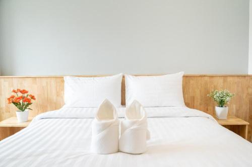 two white shoes sitting on a white bed at Meesuk ChiangRai Hotel in Chiang Rai