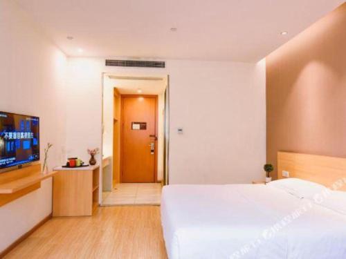 a bedroom with a large white bed and a flat screen tv at 7 Days Premium Chongqing Longtou Temple North Railway Station Center in Chongqing