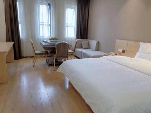 a bedroom with a bed and a living room with a table at 7 Days Premium Chongqing Longtou Temple North Railway Station Center in Chongqing