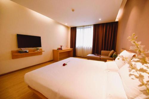 a hotel room with a large bed and a television at 7 Days Premium Chongqing Longtou Temple North Railway Station Center in Chongqing