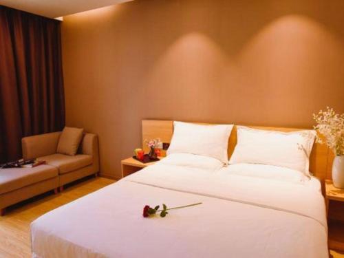 a bedroom with a large white bed and a couch at 7 Days Premium Chongqing Longtou Temple North Railway Station Center in Chongqing