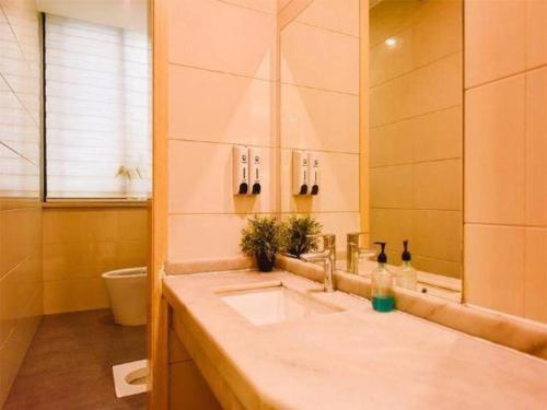 a bathroom with a sink and a toilet at 7 Days Premium Chongqing Longtou Temple North Railway Station Center in Chongqing