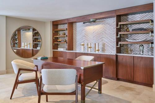 a dining room with a desk and chairs and a mirror at The St. Regis Bermuda Resort in Saint George