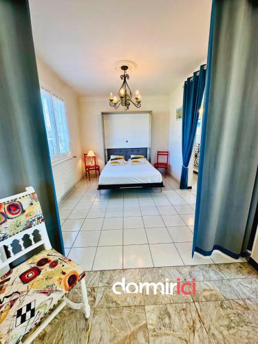 une chambre avec un lit et des chaises dans une pièce dans l'établissement SOLEIL LEVANT - Terrasse, clim, jardin & BBQ, à Arvert