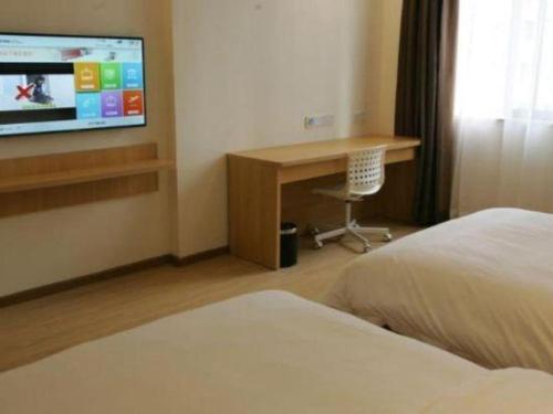 a hotel room with a bed and a desk and a tv at 7 Days Premium Chongqing Longtou Temple North Railway Station Center in Chongqing