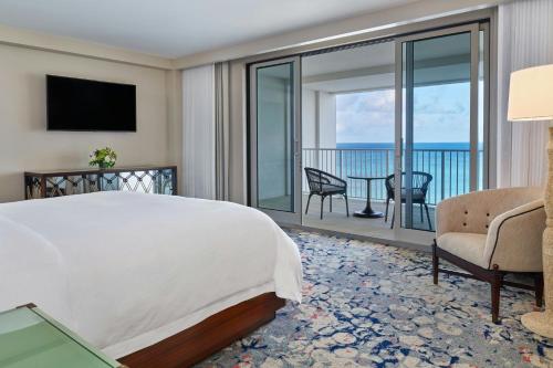 a bedroom with a bed and a view of the ocean at The St. Regis Bermuda Resort in Saint George