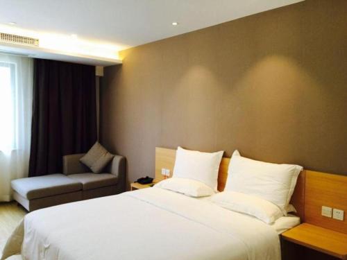 a hotel room with a bed and a chair at 7 Days Premium Chongqing Longtou Temple North Railway Station Center in Chongqing