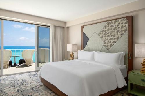 a bedroom with a bed and a view of the ocean at The St. Regis Bermuda Resort in Saint George