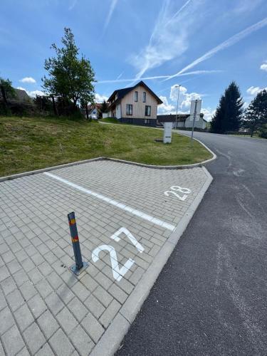 a parking lot with a handicapped sign on the road at Apartmán Skis in Černá v Pošumaví