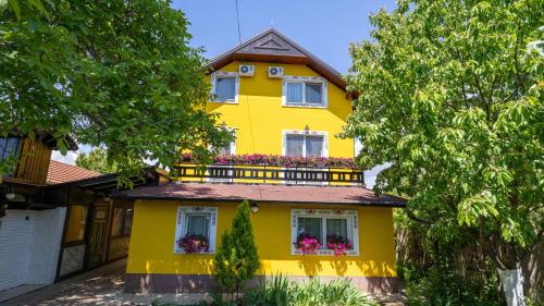 a yellow house with a balcony at Imanje Borkonjić in Ruma