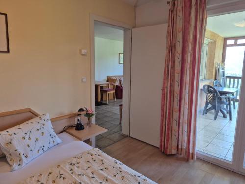a bedroom with a bed and a sliding glass door at Apartmenthaus am Waalweg in Caines