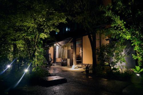 a building at night with lights in front of it at Shinwaen in Aso