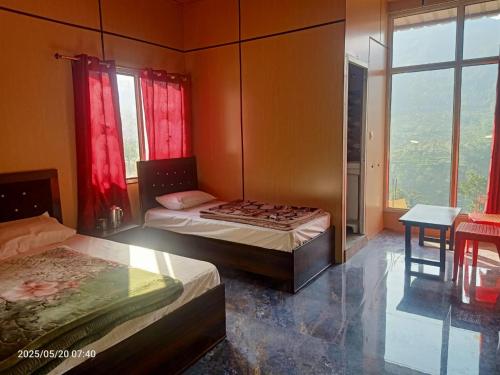 Un dormitorio con dos camas y una mesa y ventanas. en Krishna Home Stay, en Gopeshwar